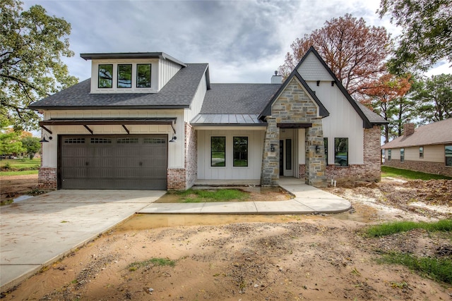 modern farmhouse featuring a garage, a shingled roof, concrete driveway, metal roof, and brick siding