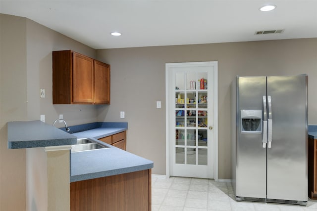 kitchen with recessed lighting, a sink, visible vents, stainless steel refrigerator with ice dispenser, and brown cabinets