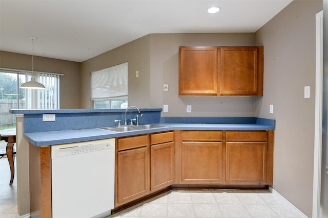 kitchen featuring brown cabinets, white dishwasher, hanging light fixtures, and a sink