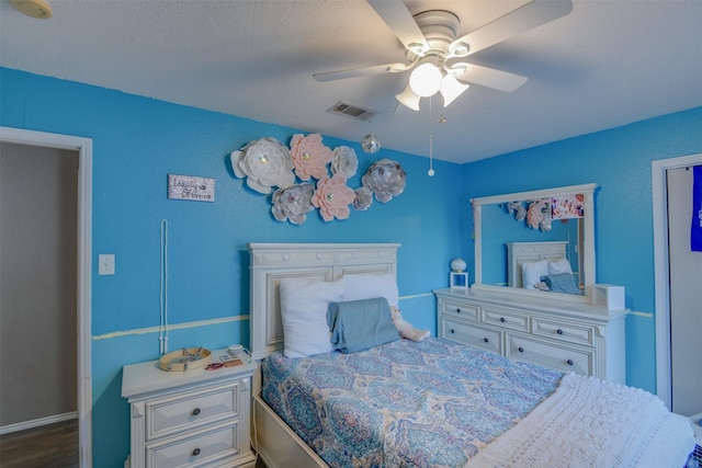 bedroom featuring dark wood-style floors, visible vents, and a ceiling fan