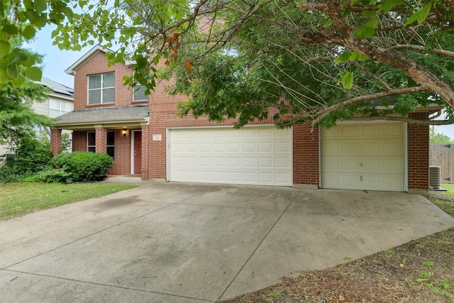 traditional-style house with concrete driveway, brick siding, and central AC unit