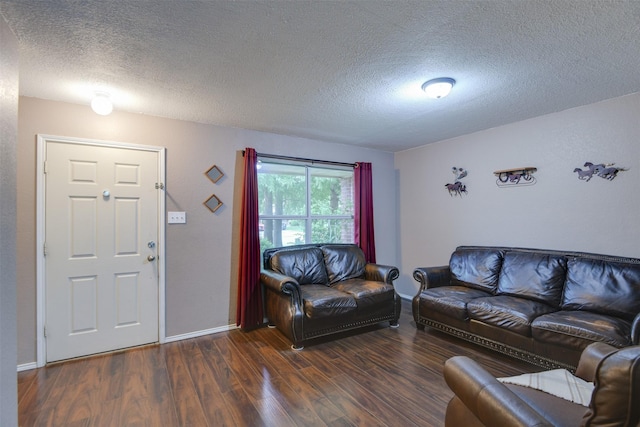 living room with dark wood-style floors, a textured ceiling, and baseboards