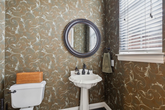 bathroom with toilet and wallpapered walls