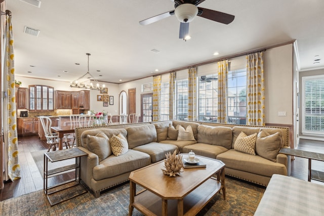 living room featuring recessed lighting, ceiling fan with notable chandelier, dark wood-type flooring, visible vents, and crown molding