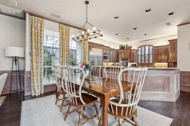 dining room with ornamental molding, a wainscoted wall, visible vents, and dark wood-style floors