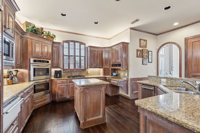 kitchen featuring visible vents, a kitchen island, light stone counters, and appliances with stainless steel finishes