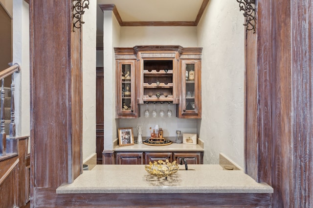 bar with ornamental molding, a textured wall, and a bar