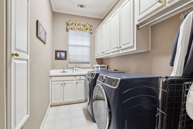 washroom featuring light tile patterned floors, a sink, visible vents, independent washer and dryer, and cabinet space