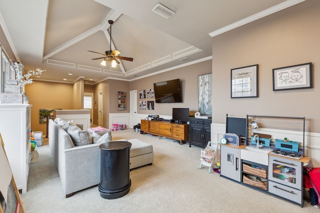 carpeted living room with a wainscoted wall, a ceiling fan, visible vents, and crown molding