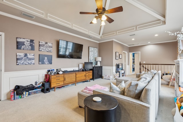 living area with a decorative wall, a wainscoted wall, visible vents, ornamental molding, and carpet