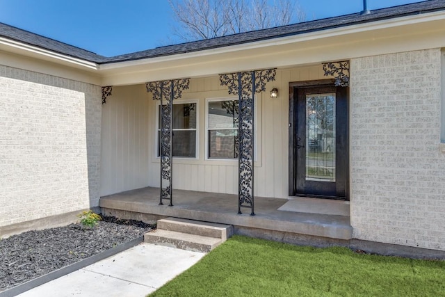 doorway to property with brick siding, board and batten siding, and covered porch