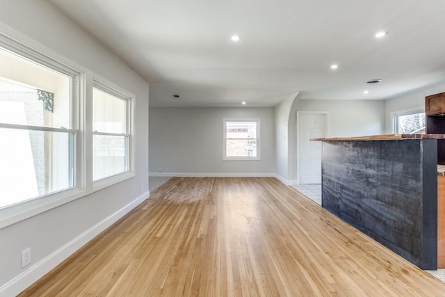 unfurnished living room with light wood finished floors, baseboards, and recessed lighting