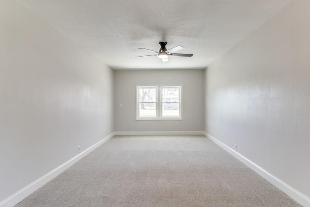 empty room featuring light carpet, ceiling fan, and baseboards