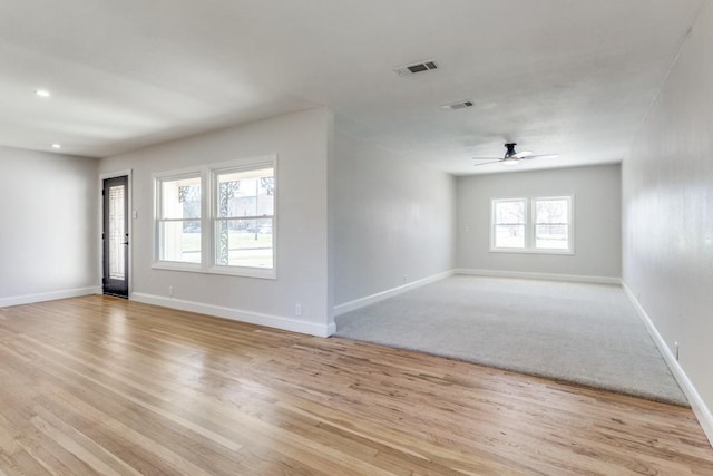unfurnished living room featuring visible vents, ceiling fan, wood finished floors, and baseboards