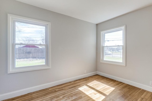 unfurnished room with light wood-type flooring and baseboards