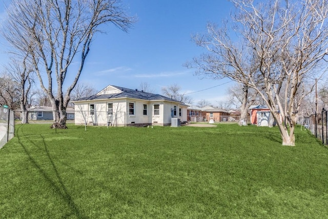 back of property featuring a yard, fence, and crawl space