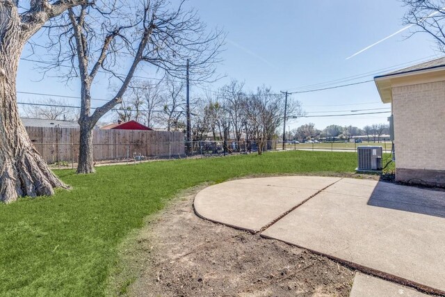 view of yard featuring central AC, fence, and a patio