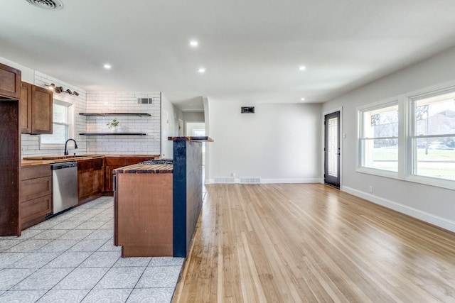 kitchen with tasteful backsplash, open shelves, plenty of natural light, and dishwasher