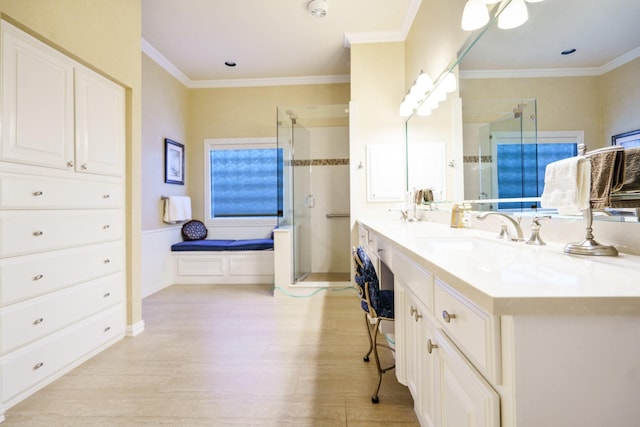 bathroom featuring crown molding, a sink, a shower stall, and double vanity