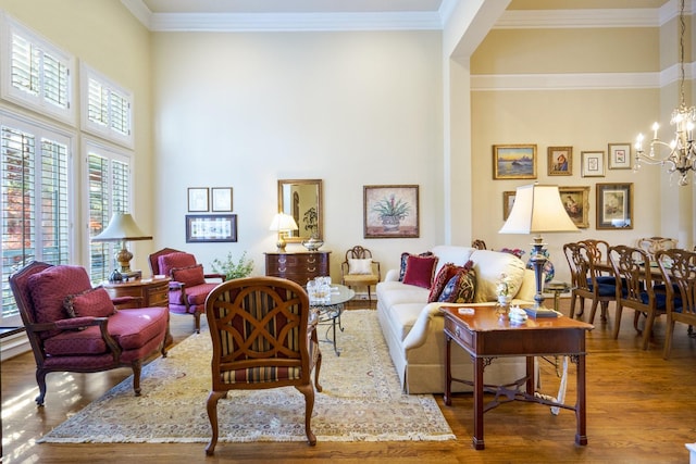 interior space with ornamental molding, wood finished floors, and an inviting chandelier