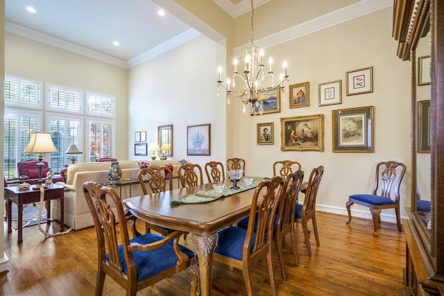 dining room featuring crown molding, recessed lighting, wood finished floors, a chandelier, and baseboards