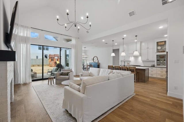 2412 Strolling Way, Argyle, TX 76226 - living room featuring a chandelier, light wood-type flooring, recessed lighting, a fireplace, and a high ceiling