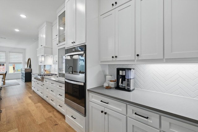 2412 Strolling Way, Argyle, TX 76226 - kitchen featuring stainless steel appliances, decorative backsplash, white cabinets, recessed lighting, and light wood-style flooring