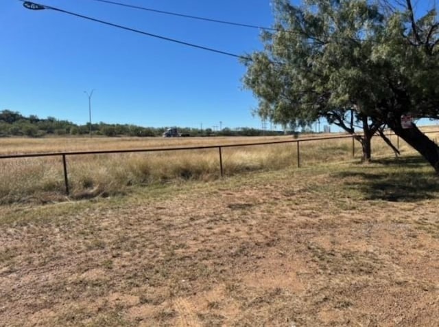 view of yard with a rural view and fence