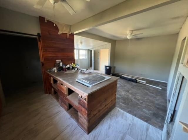 kitchen with a ceiling fan and beamed ceiling