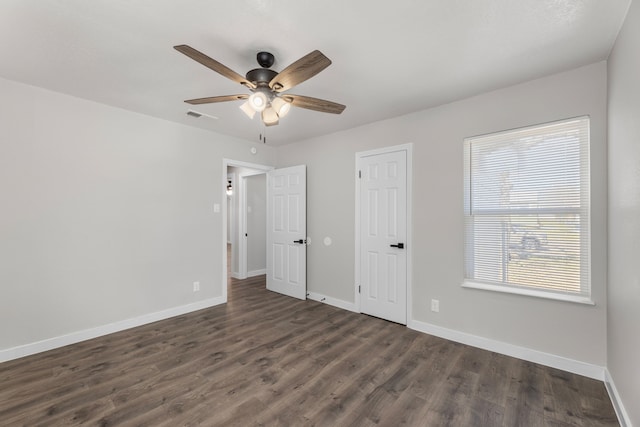 unfurnished bedroom with dark wood-type flooring, visible vents, ceiling fan, and baseboards