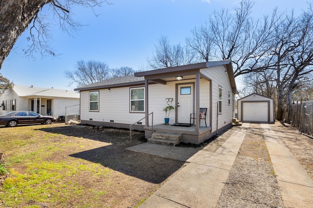 view of front of house featuring an outbuilding, a detached garage, fence, concrete driveway, and crawl space