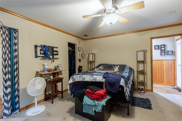 carpeted bedroom with visible vents, baseboards, a ceiling fan, and crown molding