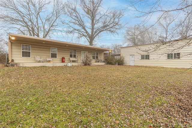 back of property featuring a lawn and a patio