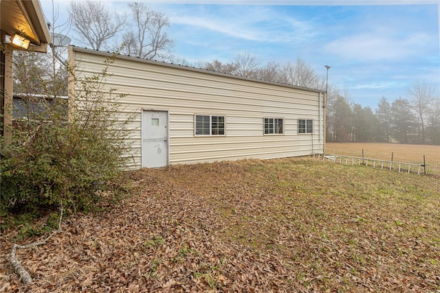 rear view of house featuring a yard and fence