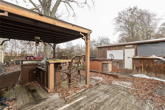 deck with outdoor dry bar, ceiling fan, a grill, and a hot tub