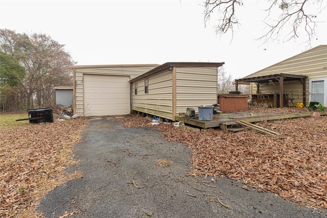 view of side of property featuring driveway, a hot tub, and a garage