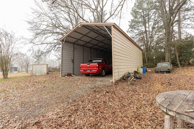 view of shed with a carport and driveway