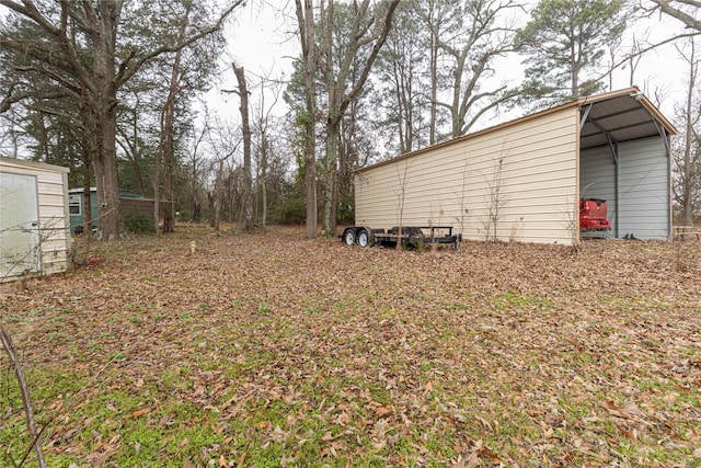 view of yard featuring a pole building, an outbuilding, and a detached carport