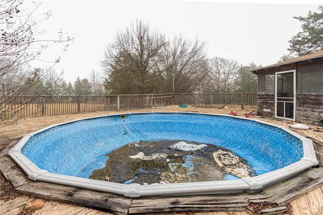 view of swimming pool featuring a sunroom, a fenced backyard, and a fenced in pool