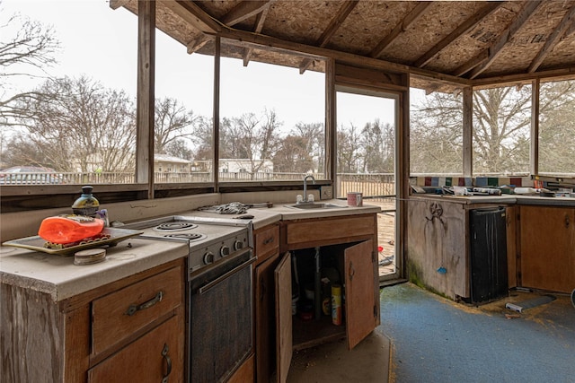 kitchen featuring white electric stove and a sink