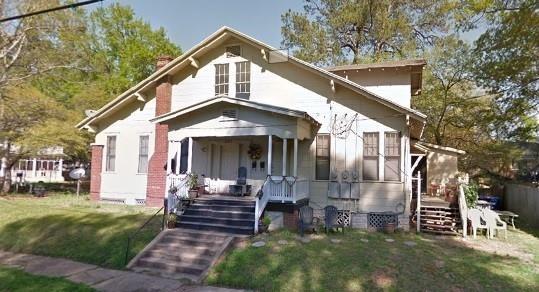 bungalow-style home featuring covered porch and a front lawn