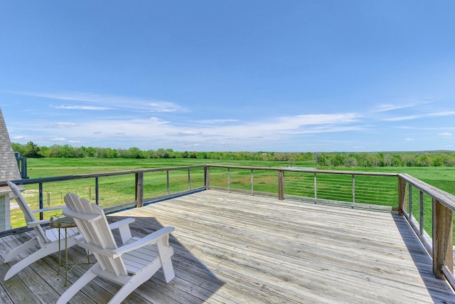 wooden deck featuring a rural view and a yard