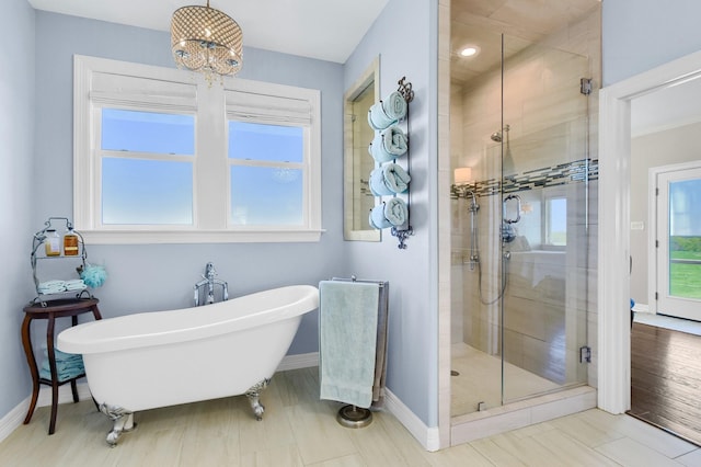 full bath with a freestanding bath, a stall shower, plenty of natural light, and baseboards