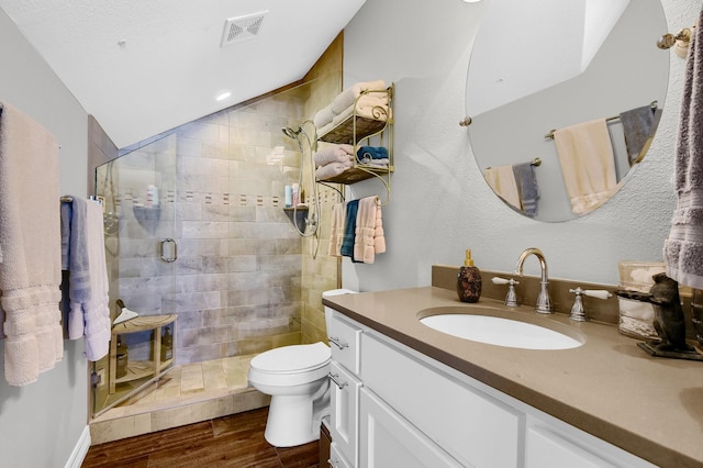 bathroom featuring toilet, wood finished floors, vanity, visible vents, and a shower stall