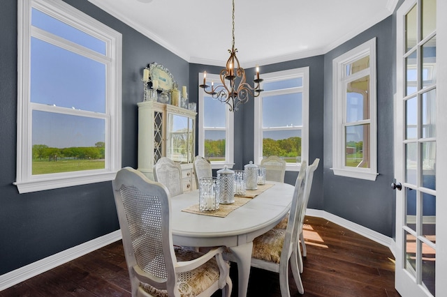 dining space featuring ornamental molding, dark wood-style flooring, baseboards, and an inviting chandelier