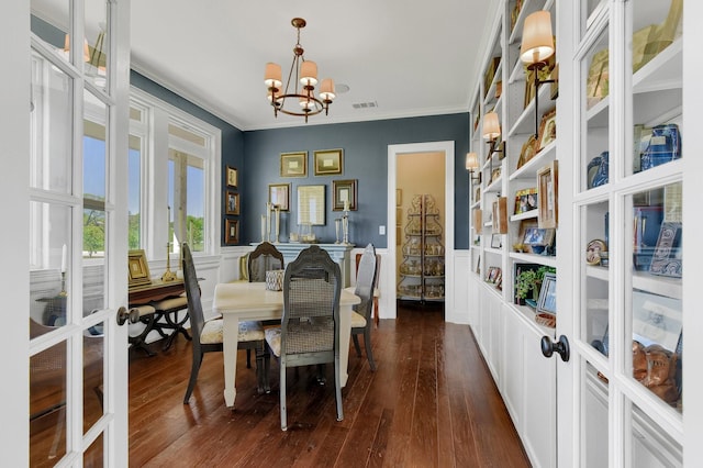 dining space featuring visible vents, a wainscoted wall, crown molding, french doors, and a notable chandelier