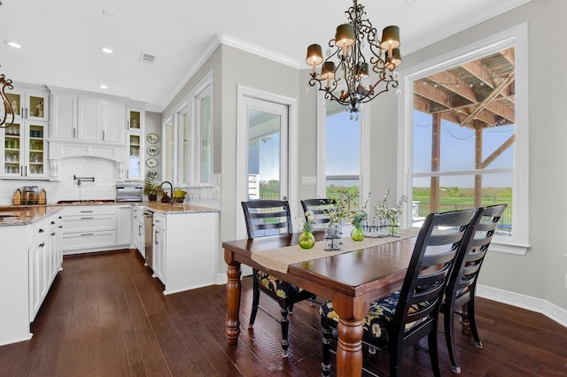 dining room with dark wood-style floors, plenty of natural light, and crown molding