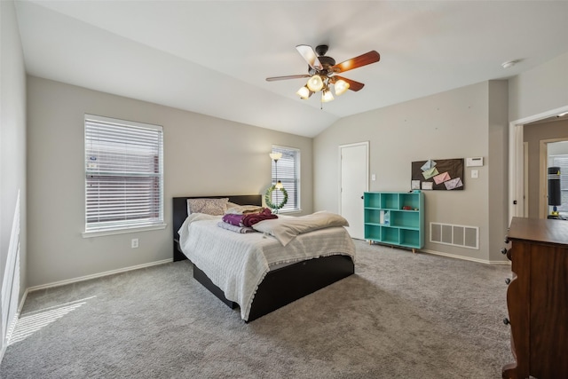 carpeted bedroom with a ceiling fan, visible vents, vaulted ceiling, and baseboards