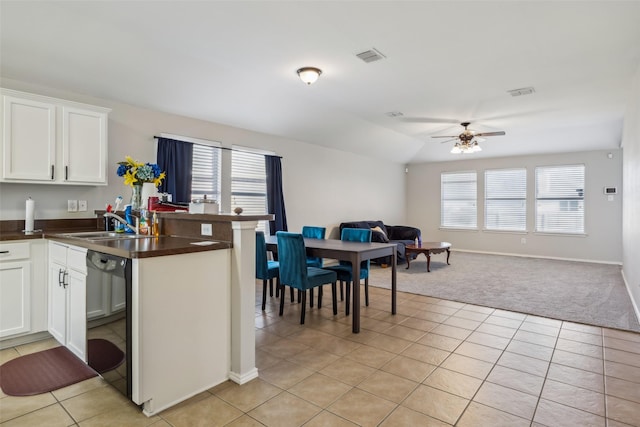 kitchen featuring open floor plan, dark countertops, white cabinetry, and dishwasher