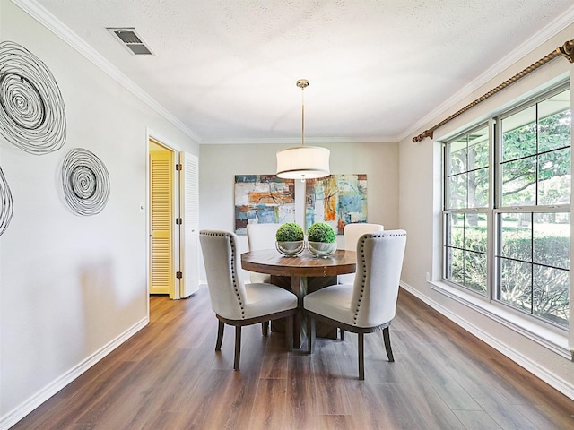 dining room with visible vents, dark wood-style flooring, and ornamental molding